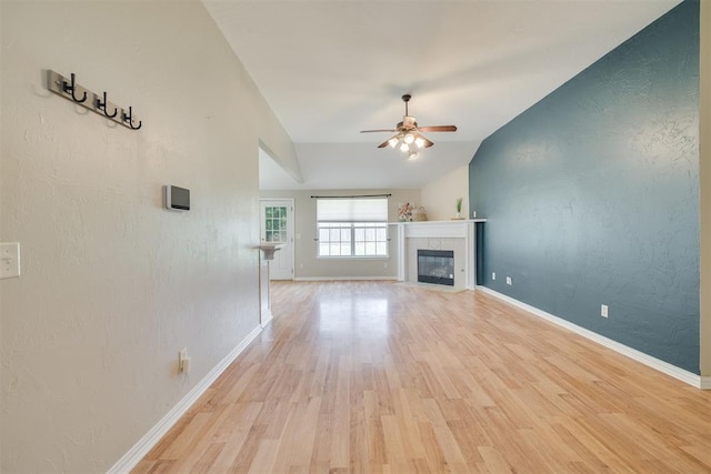 5600 Darla Dr, Oklahoma City, OK 73135 - unfurnished living room with vaulted ceiling, a ceiling fan, light wood-style floors, a fireplace, and a textured wall