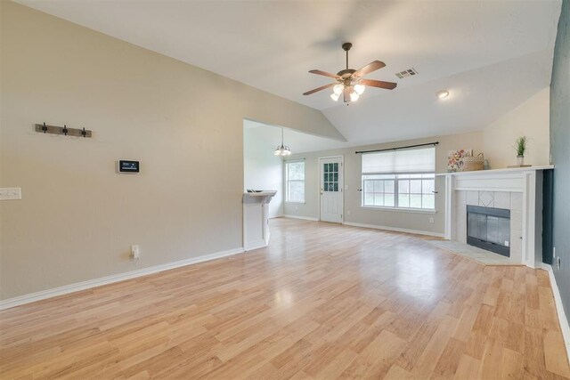 5600 Darla Dr, Oklahoma City, OK 73135 - unfurnished living room featuring a tiled fireplace, a ceiling fan, vaulted ceiling, and light wood-type flooring