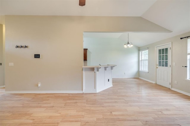 5600 Darla Dr, Oklahoma City, OK 73135 - unfurnished living room featuring vaulted ceiling, a chandelier, and light wood-style flooring