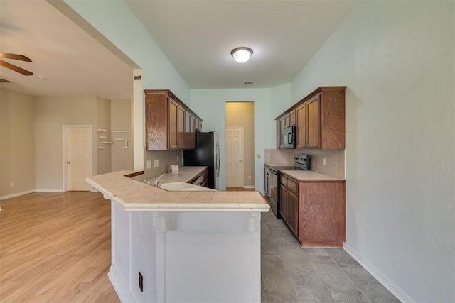 5600 Darla Dr, Oklahoma City, OK 73135 - kitchen featuring range with electric stovetop, freestanding refrigerator, backsplash, a peninsula, and ceiling fan