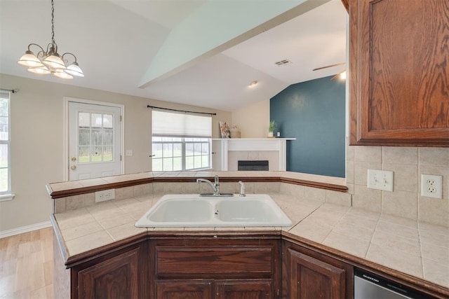 5600 Darla Dr, Oklahoma City, OK 73135 - kitchen with vaulted ceiling, dishwasher, healthy amount of natural light, tile countertops, and a fireplace