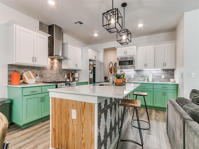 8324 NW 151st Ter, Edmond, OK 73013 - kitchen with wall chimney exhaust hood, stainless steel microwave, light wood-style floors, a kitchen breakfast bar, and tasteful backsplash