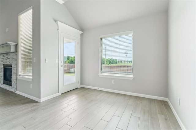 1513 Reid Pryor Rd, Norman, OK 73072 - spare room with light wood-style floors, vaulted ceiling, and a fireplace