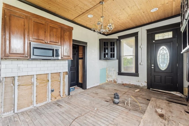 1901 E University Ave, Guthrie, OK 73044 - kitchen with stainless steel microwave, a chandelier, wood ceiling, light wood-style flooring, and brown cabinets