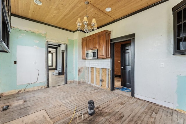 1901 E University Ave, Guthrie, OK 73044 - kitchen with stainless steel microwave, brown cabinets, light wood-style flooring, a chandelier, and wooden ceiling
