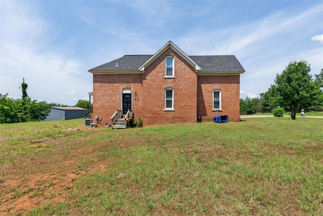 1901 E University Ave, Guthrie, OK 73044 - rear view of house featuring a yard, brick siding, and a shingled roof
