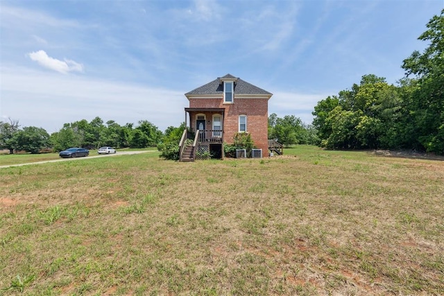 1901 E University Ave, Guthrie, OK 73044 - view of front of home featuring brick siding, stairs, covered porch, and a front lawn