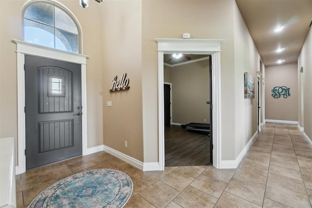 entryway featuring baseboards, light tile patterned floors, and ceiling fan