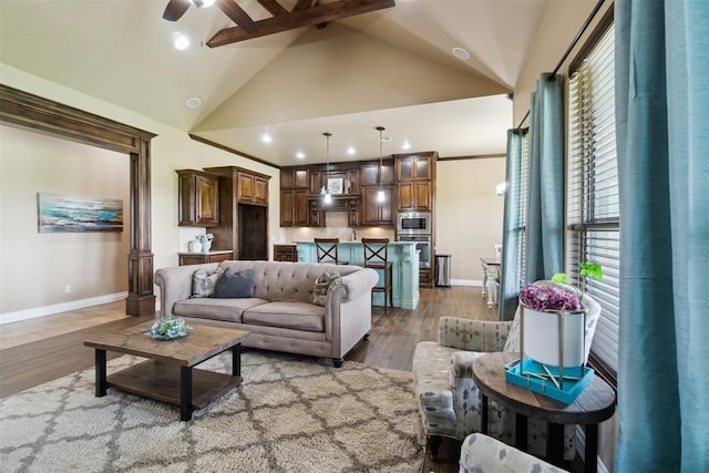 living room featuring baseboards, a ceiling fan, wood finished floors, recessed lighting, and high vaulted ceiling