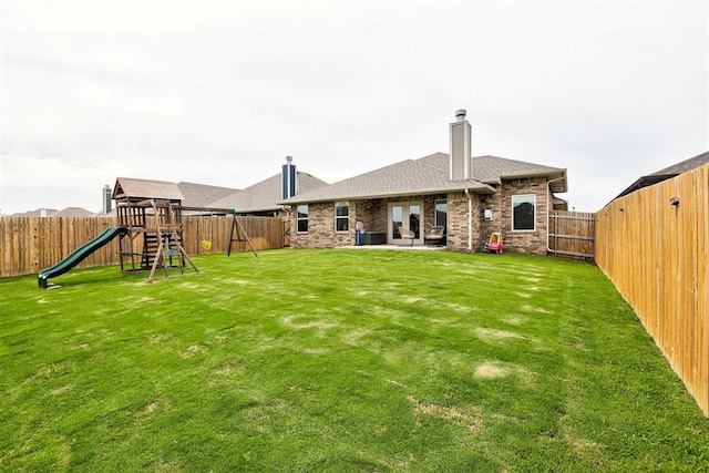 3413 NW 159th St, Edmond, OK 73013 - back of property featuring a playground, a chimney, a fenced backyard, roof with shingles, and a patio area