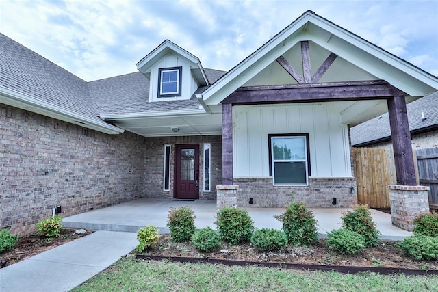 12016 SW 50th St, Mustang, OK 73064 - property entrance with roof with shingles, brick siding, and board and batten siding