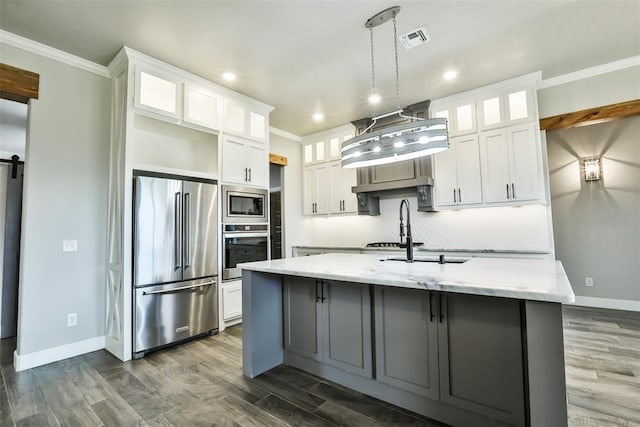 12016 SW 50th St, Mustang, OK 73064 - kitchen featuring appliances with stainless steel finishes, ornamental molding, a center island with sink, white cabinets, and dark wood-style floors