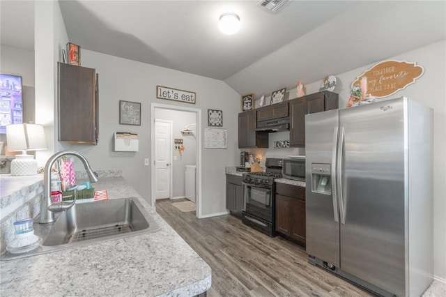 11513 Ruger Rd, Yukon, OK 73099 - kitchen featuring appliances with stainless steel finishes, a sink, wood finished floors, dark brown cabinetry, and light countertops