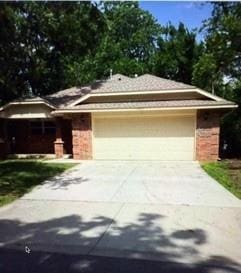 1523 Morland St, Norman, OK 73071 - view of front of home with driveway, a garage, and brick siding