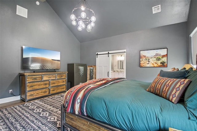 3154 Red Ridge Dr, Blanchard, OK 73010 - bedroom featuring vaulted ceiling, wood finished floors, a barn door, ensuite bathroom, and baseboards