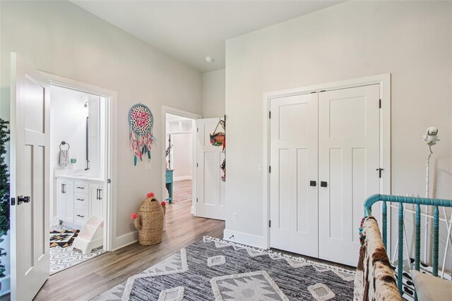 3154 Red Ridge Dr, Blanchard, OK 73010 - bedroom featuring wood finished floors, a closet, baseboards, and connected bathroom