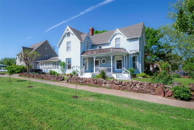 201 W 8th St, Chandler, OK 74834 - victorian home featuring a porch, a front lawn, and a chimney