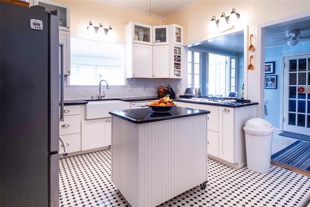 201 W 8th St, Chandler, OK 74834 - kitchen with freestanding refrigerator, light flooring, a sink, a center island, and white cabinetry