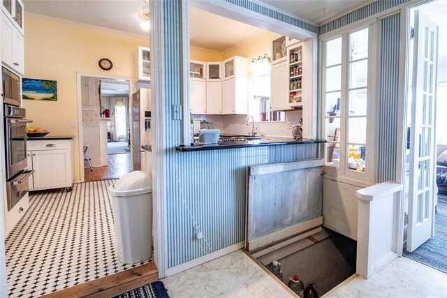 201 W 8th St, Chandler, OK 74834 - kitchen featuring crown molding, stainless steel oven, plenty of natural light, a warming drawer, and white cabinetry
