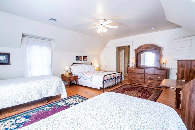 201 W 8th St, Chandler, OK 74834 - bedroom featuring wood finished floors, multiple windows, lofted ceiling, and ceiling fan