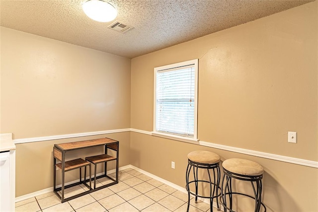 1343 E Moses St, Cushing, OK 74023 - dining room featuring light tile patterned flooring, a textured ceiling, and baseboards
