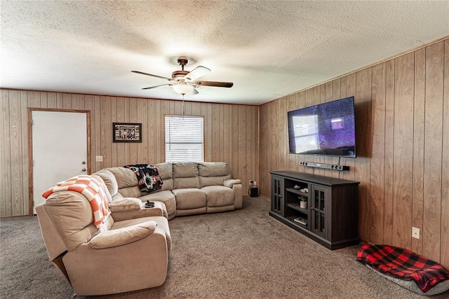 1343 E Moses St, Cushing, OK 74023 - living area featuring carpet floors, a ceiling fan, wooden walls, and a textured ceiling
