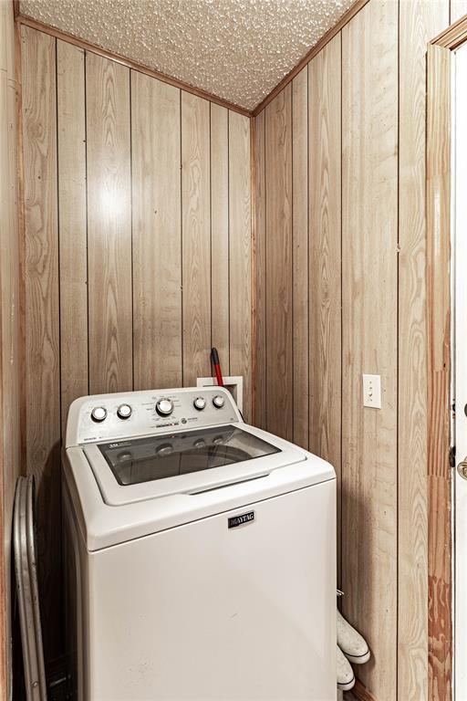 1343 E Moses St, Cushing, OK 74023 - washroom featuring washer / dryer and wooden walls