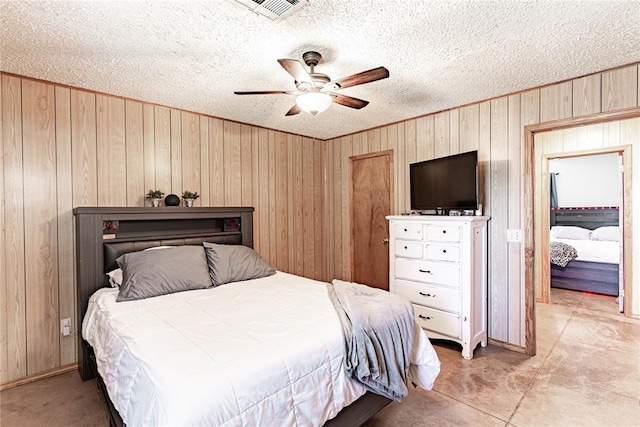 1343 E Moses St, Cushing, OK 74023 - bedroom with wooden walls, a textured ceiling, ceiling fan, and baseboards