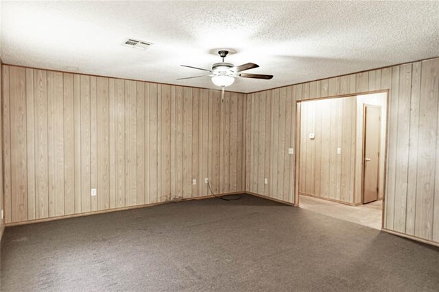 1343 E Moses St, Cushing, OK 74023 - carpeted spare room featuring a ceiling fan, wooden walls, and a textured ceiling