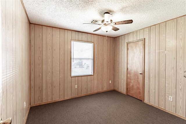 1343 E Moses St, Cushing, OK 74023 - carpeted spare room featuring ceiling fan, wooden walls, and a textured ceiling