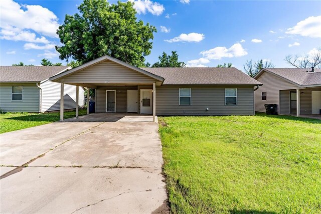 1343 E Moses St, Cushing, OK 74023 - ranch-style house with driveway, a front lawn, and a carport