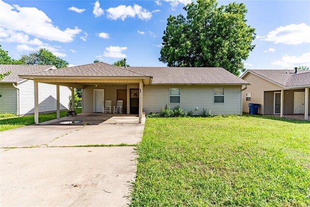 1343 E Moses St, Cushing, OK 74023 - ranch-style home with concrete driveway, a front lawn, a carport, and a shingled roof