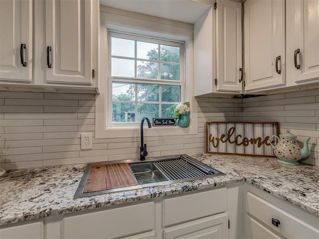 2417 SW 47th St, Oklahoma City, OK 73129 - kitchen featuring tasteful backsplash, white cabinets, and a sink