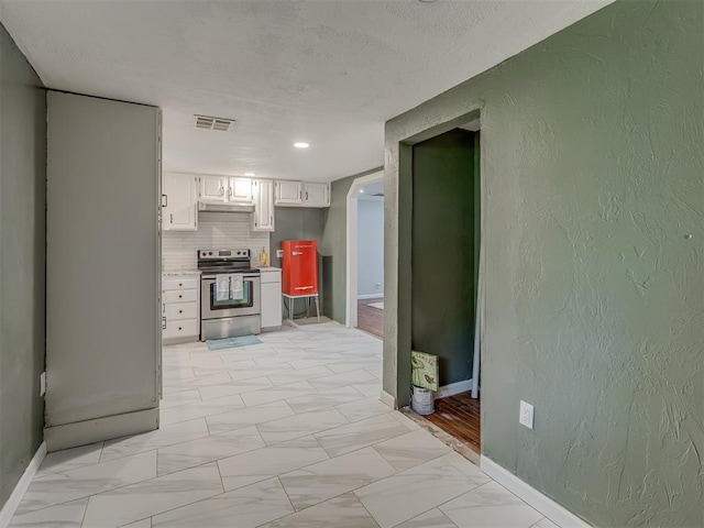 2417 SW 47th St, Oklahoma City, OK 73129 - kitchen featuring stainless steel electric range, baseboards, white cabinetry, light marble finish flooring, and light countertops