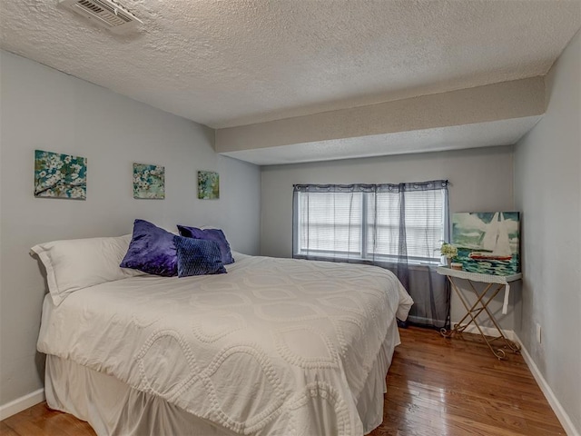 2417 SW 47th St, Oklahoma City, OK 73129 - bedroom featuring wood finished floors, a textured ceiling, and baseboards