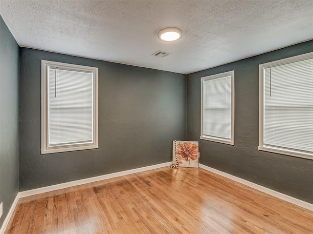 2417 SW 47th St, Oklahoma City, OK 73129 - empty room with wood finished floors, a textured ceiling, and baseboards