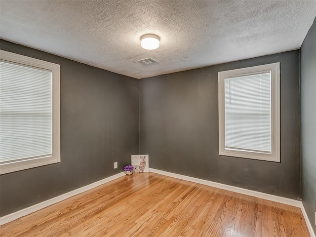 2417 SW 47th St, Oklahoma City, OK 73129 - empty room with wood finished floors, a textured ceiling, and baseboards