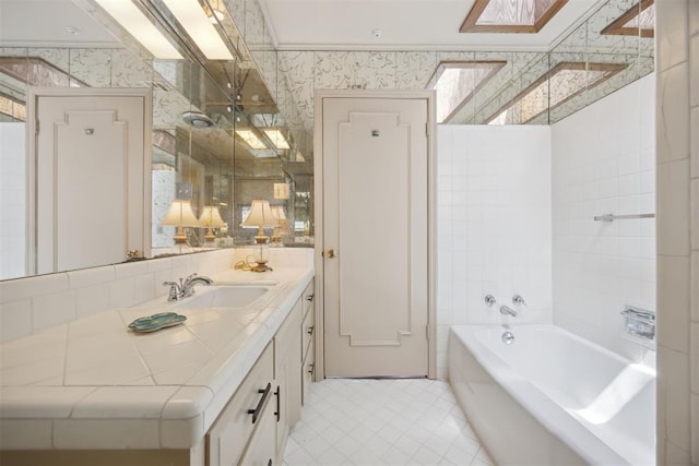 2917 W Pelham Dr, Oklahoma City, OK 73120 - full bathroom with wallpapered walls, a skylight, vanity, a tub to relax in, and tile patterned flooring