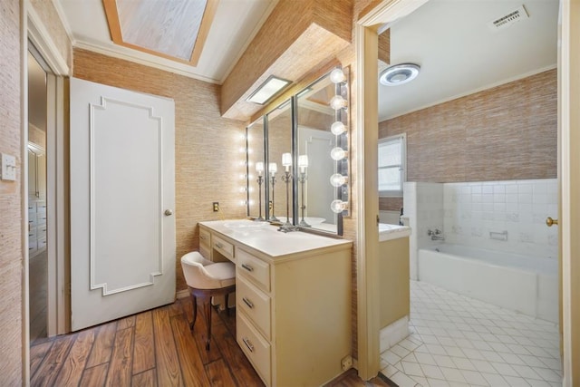 2917 W Pelham Dr, Oklahoma City, OK 73120 - bathroom featuring vanity, a garden tub, tile walls, wood finished floors, and crown molding