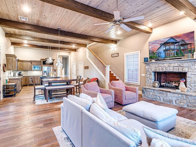 37271 S Cliff Crest Dr, Langley, OK 74301 - living room with wood ceiling with exposed beams, a ceiling fan, light wood finished floors, stairs, and a fireplace