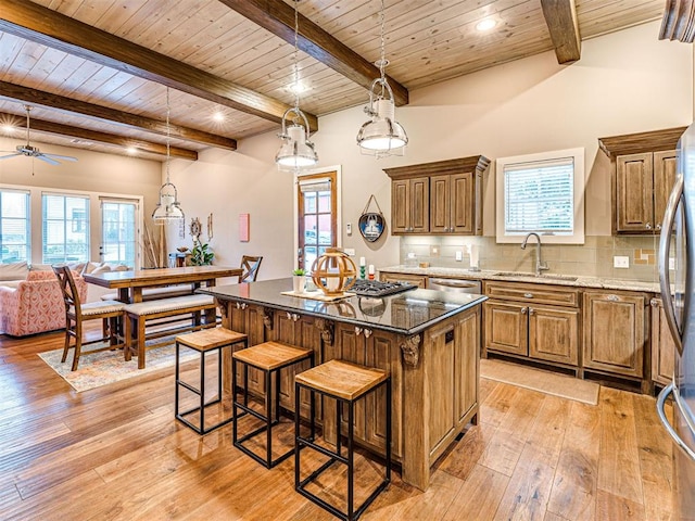 37271 S Cliff Crest Dr, Langley, OK 74301 - kitchen with a sink, wooden ceiling with exposed beams, brown cabinetry, a center island, and light wood-type flooring