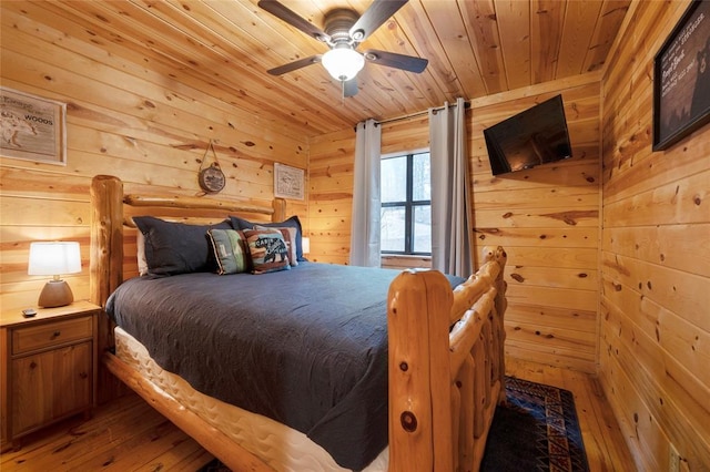 1073 Southern Hills Cir, Broken Bow, OK 74728 - bedroom with light wood-type flooring, wood ceiling, wooden walls, and a ceiling fan