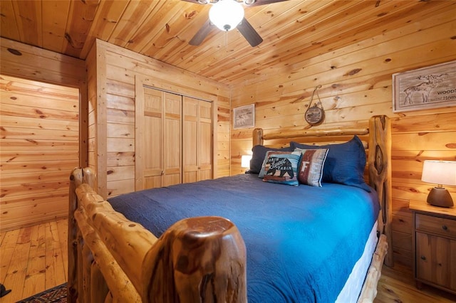 1073 Southern Hills Cir, Broken Bow, OK 74728 - bedroom featuring wooden ceiling, hardwood / wood-style flooring, wood walls, a ceiling fan, and a closet