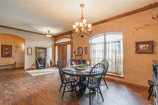 108 Raye Pl, Tuttle, OK 73089 - dining space featuring wood finished floors, a chandelier, ornamental molding, arched walkways, and a textured wall