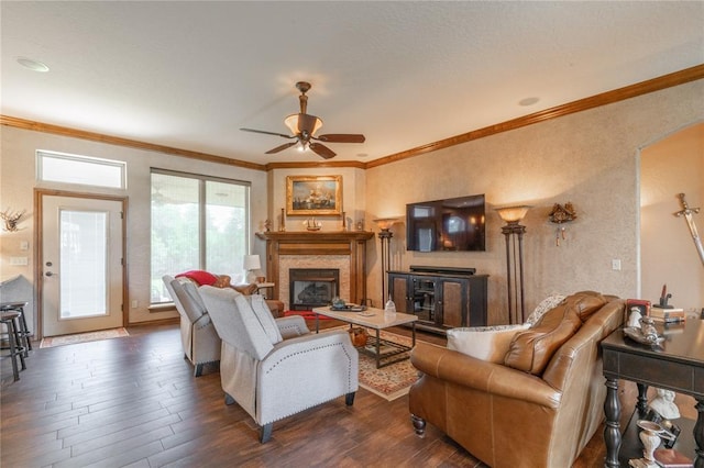 108 Raye Pl, Tuttle, OK 73089 - living room featuring a fireplace, crown molding, ceiling fan, dark wood-type flooring, and a textured wall