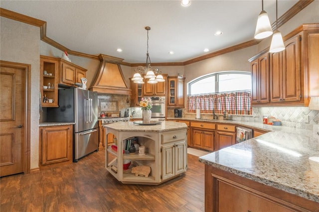 108 Raye Pl, Tuttle, OK 73089 - kitchen featuring open shelves, premium range hood, appliances with stainless steel finishes, brown cabinetry, and ornamental molding