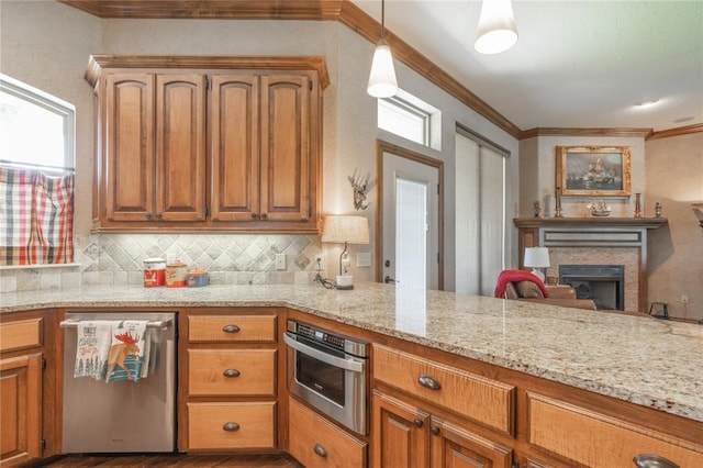 108 Raye Pl, Tuttle, OK 73089 - kitchen with appliances with stainless steel finishes, ornamental molding, decorative backsplash, light stone countertops, and a fireplace