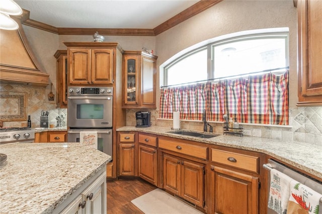 108 Raye Pl, Tuttle, OK 73089 - kitchen featuring stainless steel appliances, a sink, brown cabinetry, decorative backsplash, and crown molding