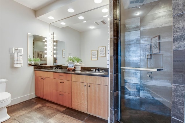 301 NE 4th St Unit 10, Oklahoma City, OK 73104 - bathroom with toilet, double vanity, a stall shower, baseboards, and tile patterned floors