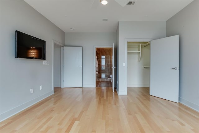 301 NE 4th St Unit 10, Oklahoma City, OK 73104 - unfurnished bedroom featuring light wood-style flooring, baseboards, and a spacious closet
